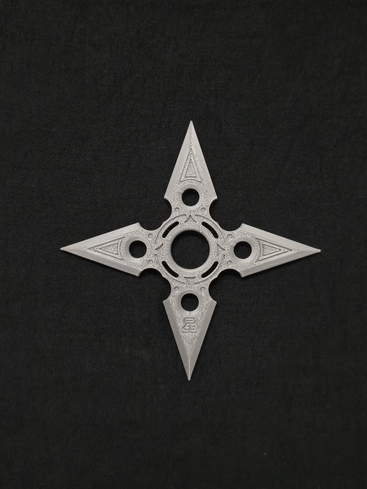 Akuryō four-point decorative shuriken on a black background
